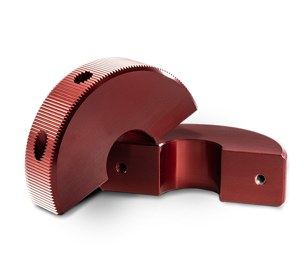 Two shiny red machined parts.