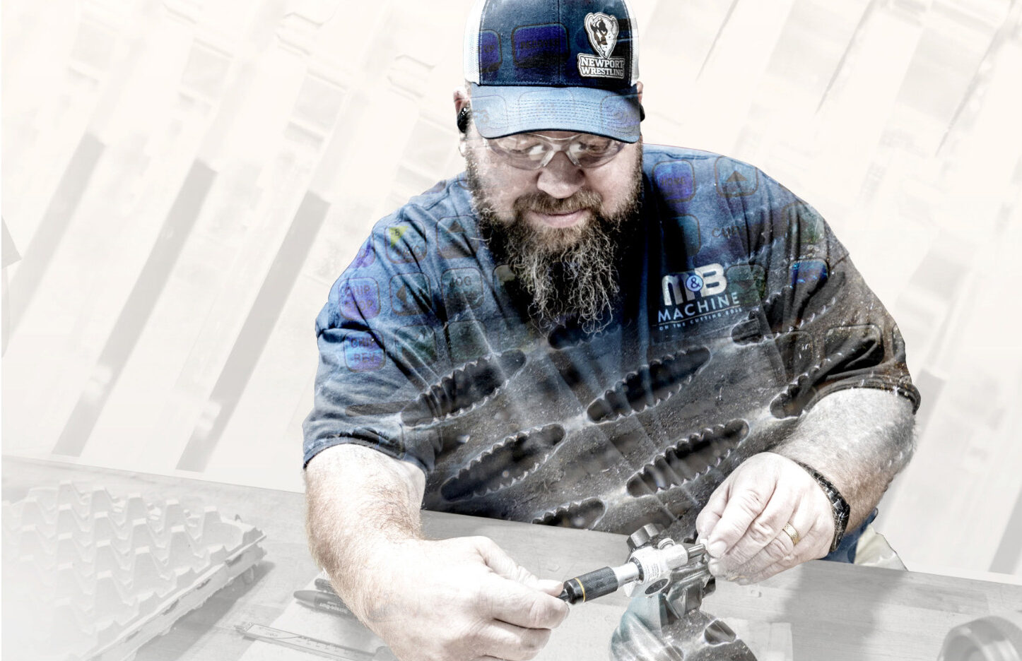 A man is in the foreground wearing a blue shirt and cap. He is measuring an object.